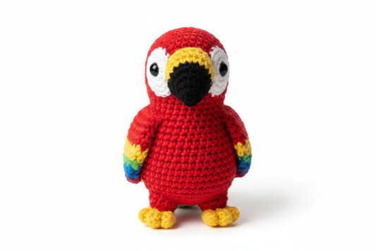 Crocheted red parrot stuffed animal on white background